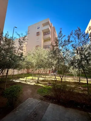 a building with a lot of trees in front of it at Appartement 2 chambres à 10mn du centre ville in Marrakech