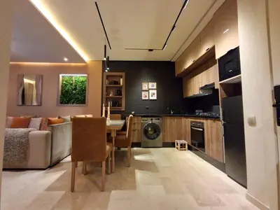a kitchen and living room with a table and a couch at Prestigia Agathe in Marrakech