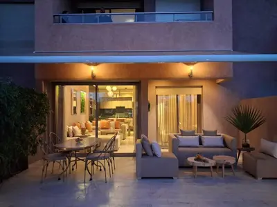 a patio with a couch and a table and chairs at Prestigia Agathe in Marrakech