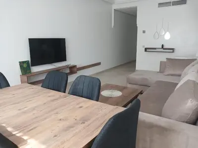 a living room with a wooden table and a couch at Appartement familial - 2 chambres - Hivernage in Marrakech