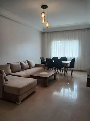 a living room with a couch and a table and chairs at Appartement familial - 2 chambres - Hivernage in Marrakech