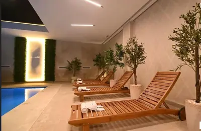 a row of benches in a room with a pool at Cozy & Modern Gueliz Apartment in Marrakech