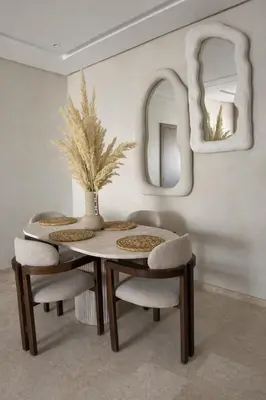 a dining room with a table and chairs and mirrors at Cozy & Modern Gueliz Apartment in Marrakech