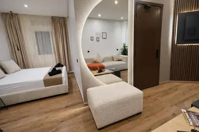 a bedroom with a bed and a living room with a couch at Studio sur guiliz avec piscine et parking in Marrakech