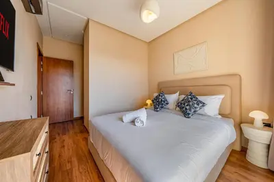 a bedroom with a large bed and a bathroom at Prestigia Jubaea Apartment Green Escape & Pool in Marrakech