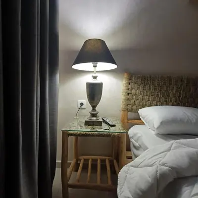 a lamp on a side table next to a bed at Dolce appartement proche de l'aéroport in Marrakech