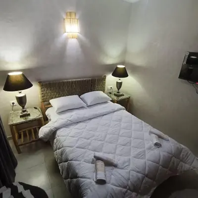 a bedroom with a large bed with two night stands at Dolce appartement proche de l'aéroport in Marrakech