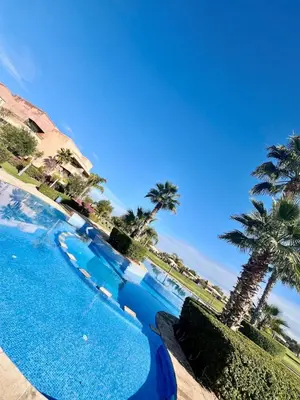a swimming pool with palm trees in the background at Marrakech Prestigia Center Pool View 3 Bedrooms in Marrakech