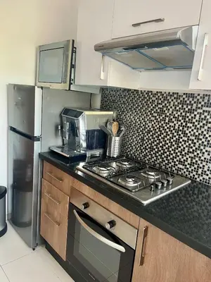 a kitchen with a stove top oven next to a refrigerator at Marrakech Prestigia Center Pool View 3 Bedrooms in Marrakech