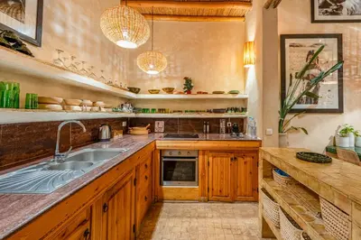 a kitchen with wooden cabinets and a sink at Riad Imani-Gorgeous Sunny Terrace Breakfast Pool in Marrakech