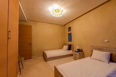 a bedroom with two beds and a chandelier at Luxury Villa Inspired by Authentic Moroccan Design in Marrakech