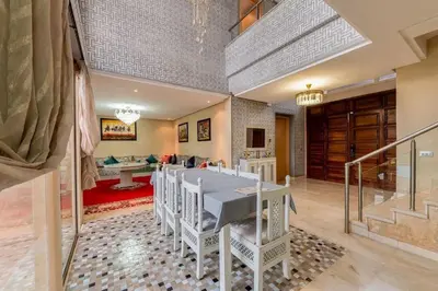 a dining room with a white table and chairs at Luxury Villa Inspired by Authentic Moroccan Design in Marrakech