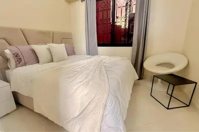 a bedroom with a white bed and a toilet at Luxury Family Apartment in Gueliz in Marrakech