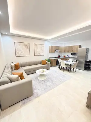 a living room with a couch and a kitchen at Elegant apartment with pool, highly desirable area in Marrakech