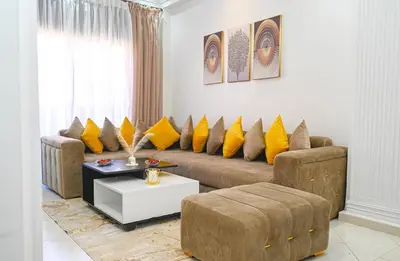 a living room with a brown couch and yellow pillows at Cosy appartement en plein cœur de Marrakech ! in Marrakech