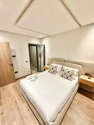 a bedroom with a large white bed with pillows at Modern apartment with jacuzzi & gym in Marrakech