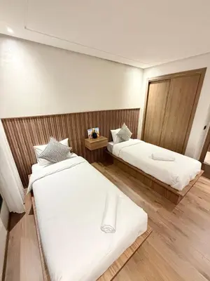 two beds in a room with wooden walls at Modern apartment with jacuzzi & gym in Marrakech