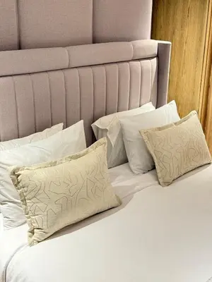 a bed with white pillows and a headboard at Apartment with pool & gym in Marrakech