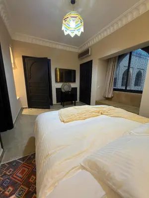 a bedroom with two beds and a chandelier at Royal Moroccan House in Marrakech