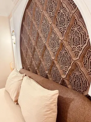 a headboard of a bed in a room with a pillow at Le cocon Majorelle in Marrakech