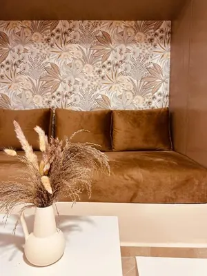 a brown leather couch with a vase on a table at Le cocon Majorelle in Marrakech