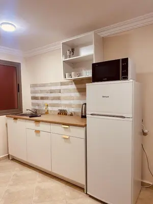 a kitchen with a white refrigerator with a microwave on top at Le cocon Majorelle in Marrakech