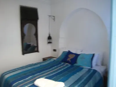 a bedroom with a bed with blue and white sheets at Riad Tanina Rooftop Central Authentic Moroccan Experience in Marrakech