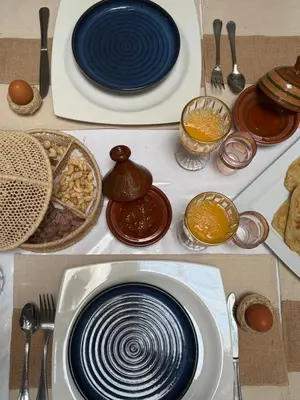 a table topped with plates and bowls of food at Riad Tanina Rooftop Central Authentic Moroccan Experience in Marrakech