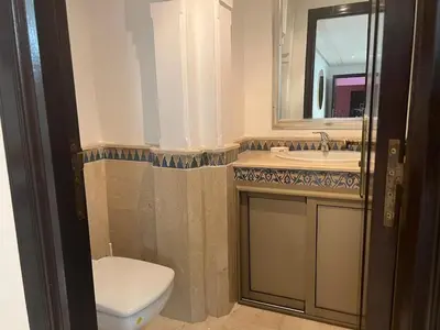 a bathroom with a toilet and a sink and a mirror at Azou Luxury apartment - Pool & Garden Marrakech in Marrakech