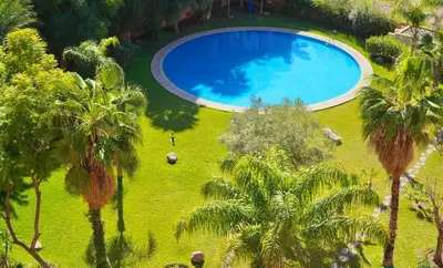 an overhead view of a large pool in a field with palm trees at Azou Luxury apartment - Pool & Garden Marrakech in Marrakech