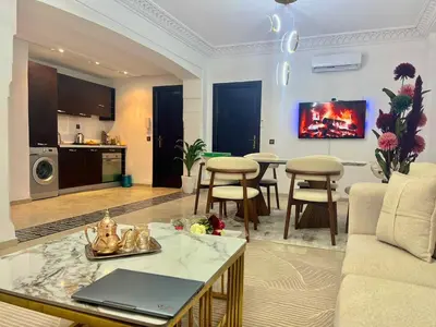 a living room with a couch and a table at Azou Luxury apartment - Pool & Garden Marrakech in Marrakech