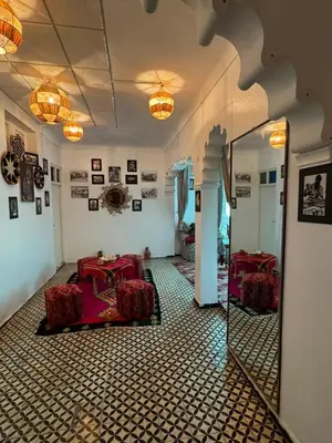 a room with red tables and a mirror in it at Appartement near to big square in Marrakech
