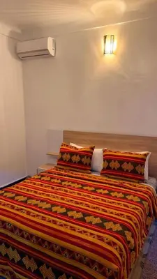 a bedroom with a bed with a colorful blanket on it at Appartement near to big square in Marrakech