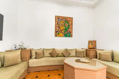 a living room with a couch and a painting on the wall at Riad melyssa in Marrakech