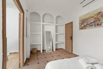 a bedroom with white walls and a bed in a room at Riad melyssa in Marrakech