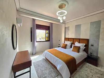 a bedroom with a bed and a table and a window at Jonas House in Marrakech