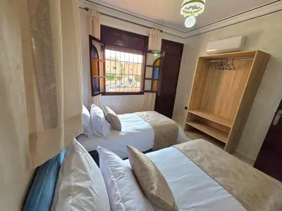a hotel room with two beds and a window at Jonas House in Marrakech