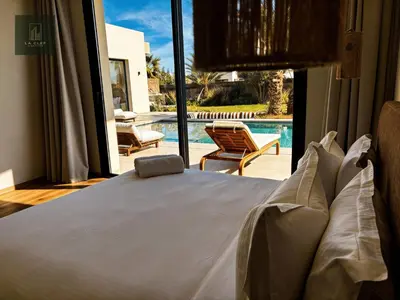 a bedroom with a bed and a view of a pool at MIKESTAY - Villa Luma in Marrakech
