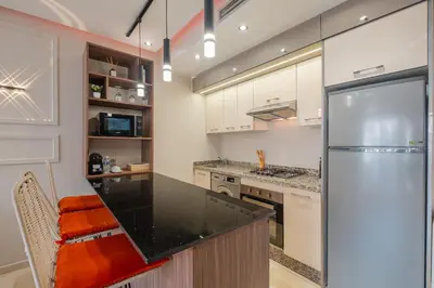a kitchen with white cabinets and a stainless steel refrigerator at Séjour luxueux pearl garden Marrakech in Marrakech