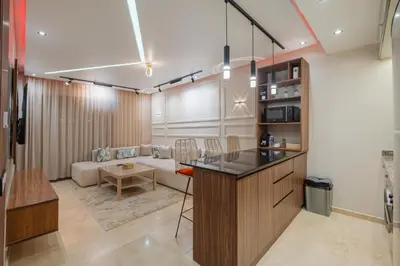a kitchen and living room with a couch and a table at Séjour luxueux pearl garden Marrakech in Marrakech