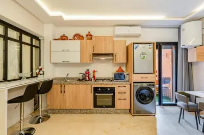 a kitchen with a refrigerator and a dishwasher at Beautiful apartment in residence with pool in Marrakech