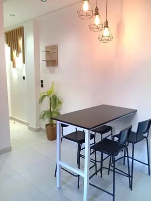 a table and chairs in a room with a wall at Perle de Guéliz Marrakech in Marrakech