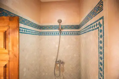 a bathroom with a shower with blue and white tile at Villa Dar Saada in Marrakech