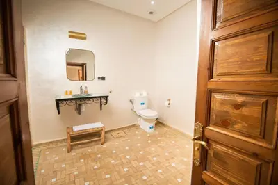 a bathroom with a toilet and a sink and a door at Villa Dar Saada in Marrakech