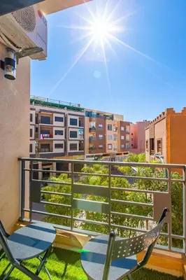 a balcony with chairs and a view of a city at Appartement familial 2 ch Wi-Fi 15 min centre in Marrakech