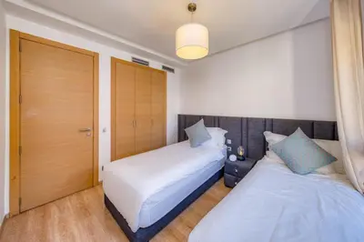a bedroom with two beds and a closet at Family Apartment 3 Bedrooms Prestigia with Pool in Marrakech