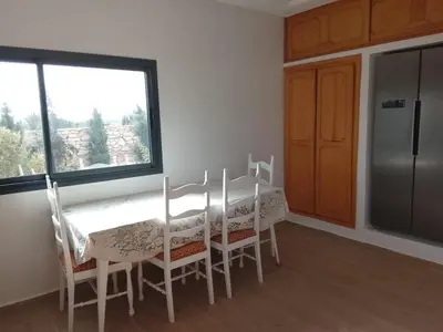 a kitchen with a table and chairs and a window at Alexandra Nomade - Maison de transition & séjours de répit in Marrakech