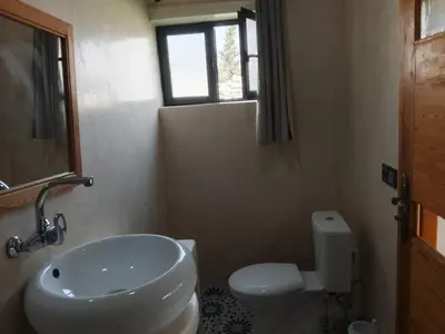 a bathroom with a sink and a toilet and a window at Alexandra Nomade - Maison de transition & séjours de répit in Marrakech