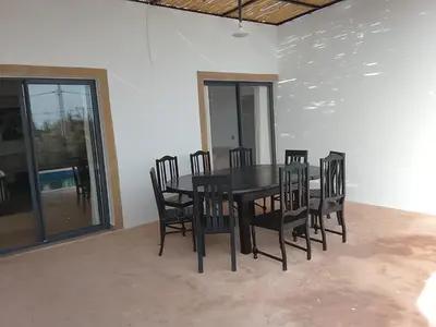 a dining room with a black table and chairs at Alexandra Nomade - Maison de transition & séjours de répit in Marrakech