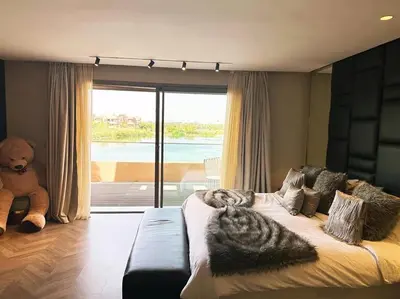 a bedroom with a large bed with a teddy bear at Villa du Lac 4 suites in Prestigia in Marrakech
